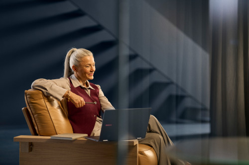 A woman smiles while using a laptop
