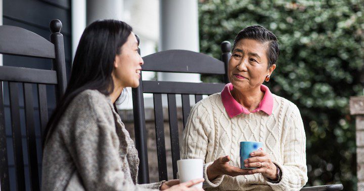 A mother speaks with her daughter while drinking tea