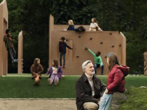 A man talks to his daughter a the playground